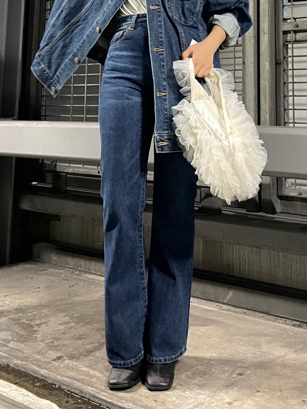 ホワイト系のショルダーバッグ、ブルー系のデニムジャケット、ブルー系のデニムパンツを着用したレディースの夏コーディネートの6枚目の写真