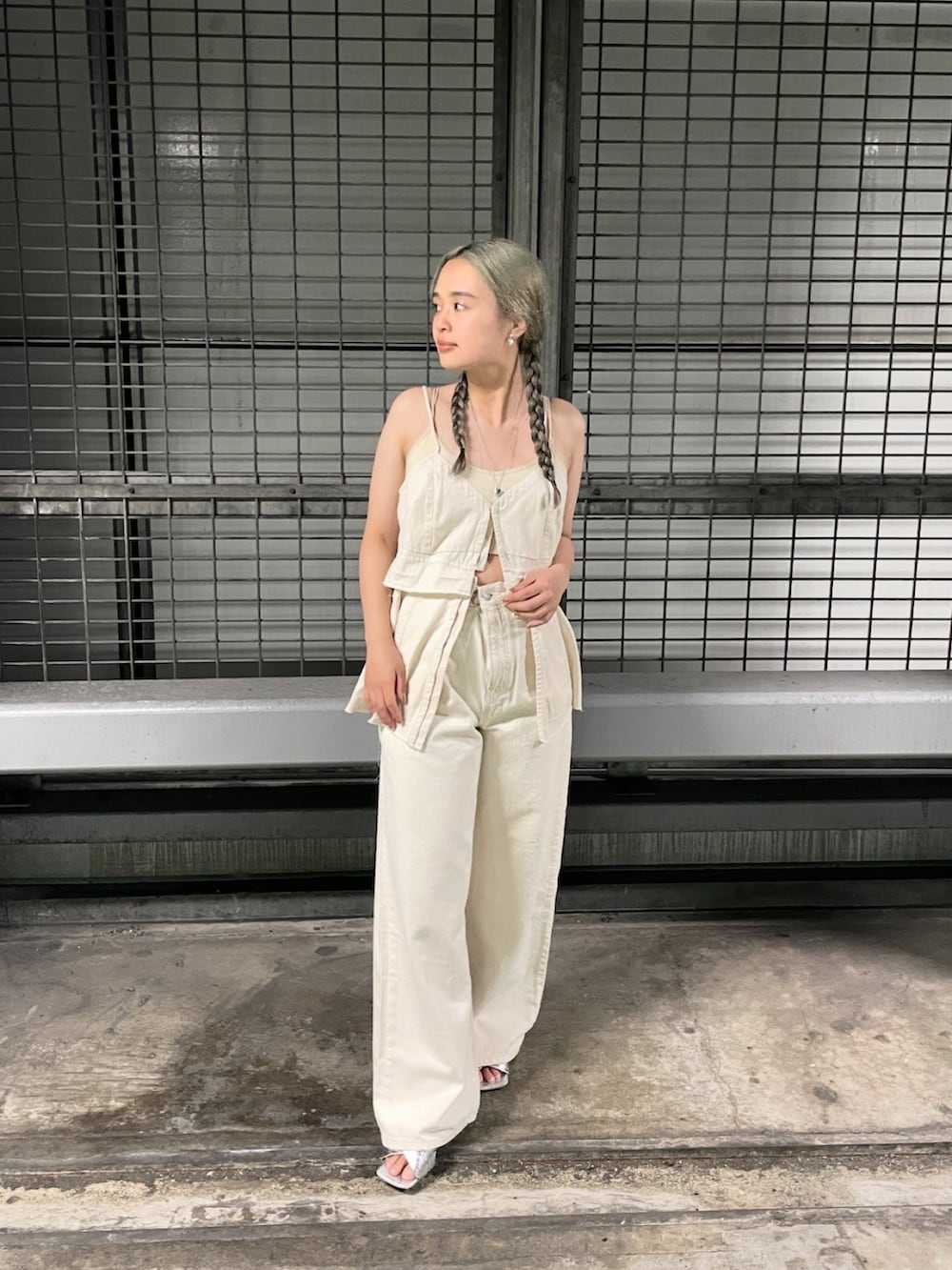 ホワイト系のデニムパンツ、ホワイト系のキャミソール、シルバー系のサンダルを着用したレディースの春コーディネートの2枚目の写真