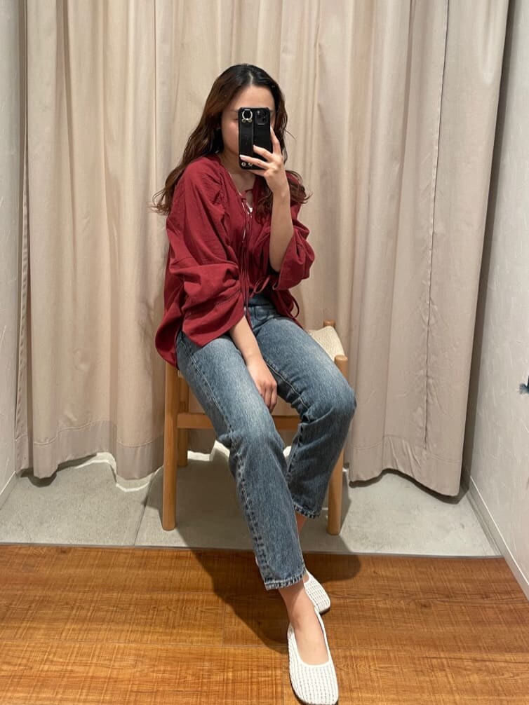 ホワイト系のパンプス、ホワイト系のタンクトップ、ブルー系のデニムパンツを着用したレディースの春コーディネートの2枚目の写真