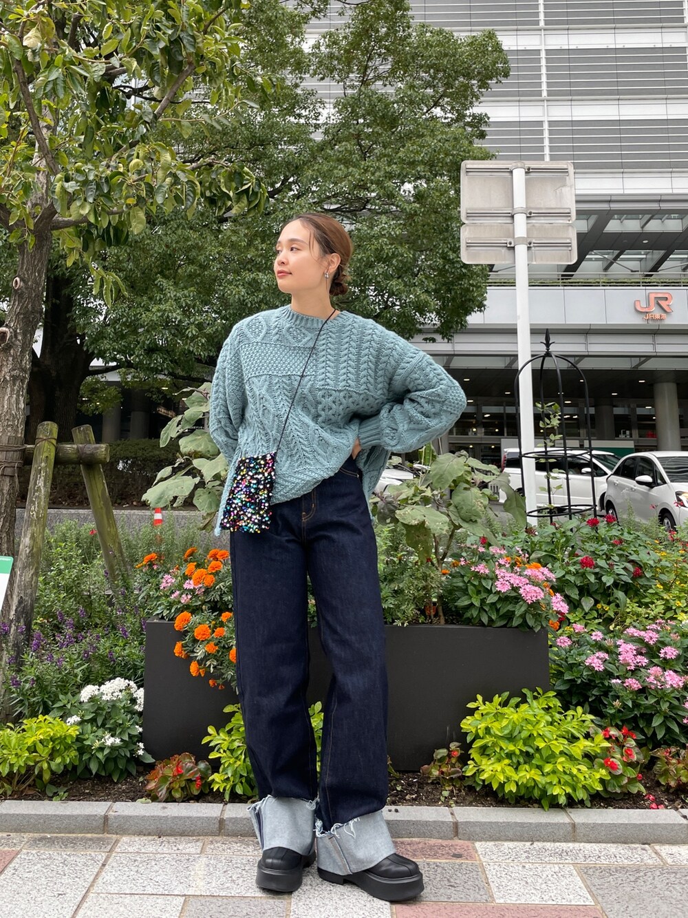 ブルー系のニット/セーター、ブルー系のデニムパンツ、その他のショルダーバッグを着用したレディースの秋コーディネートの3枚目の写真