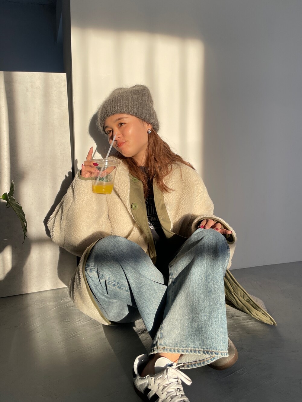 ホワイト系のブルゾン、ブルー系のデニムパンツを着用したレディースの冬コーディネートの5枚目の写真