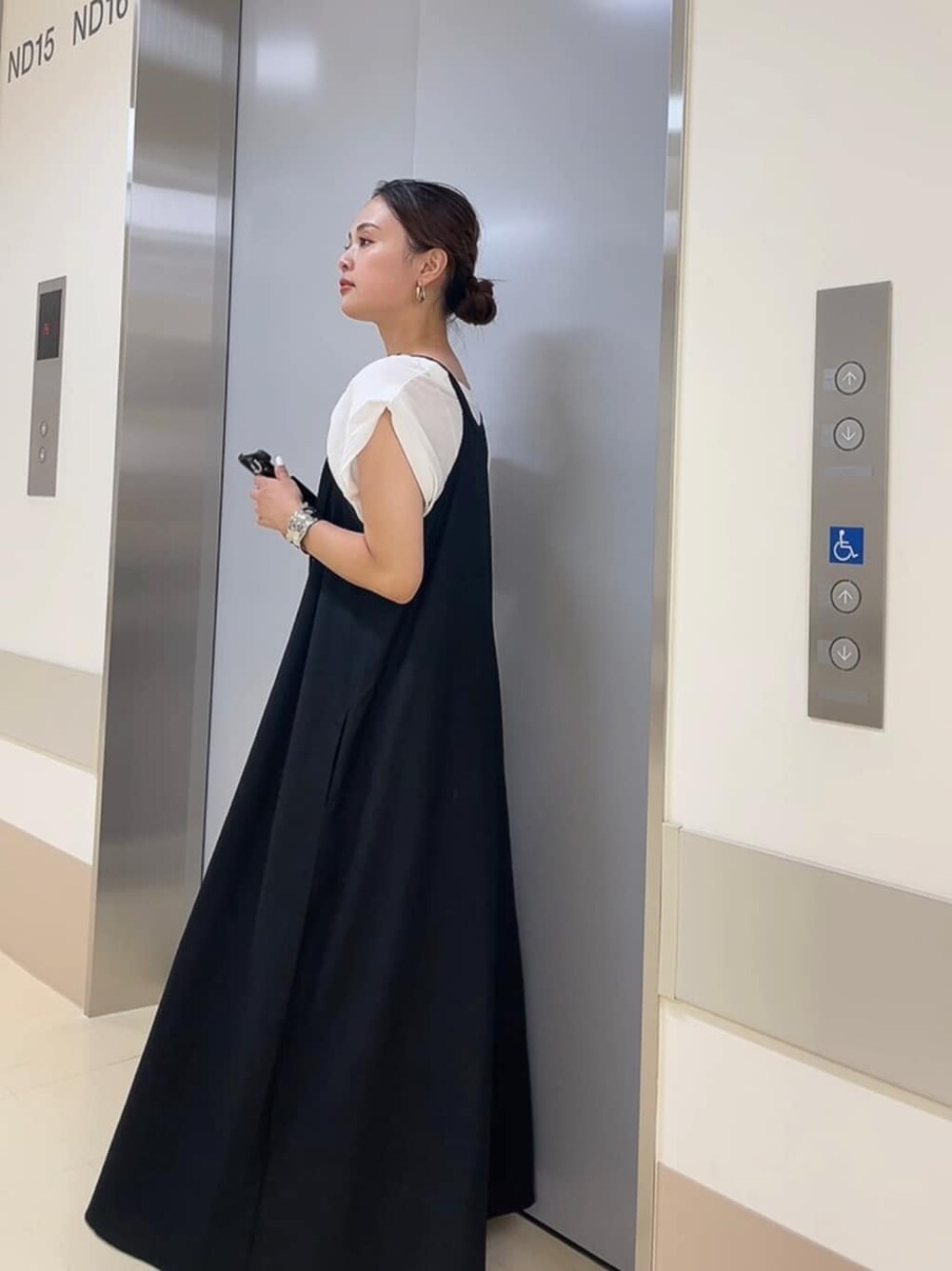 ブラック系のサンダル、ホワイト系のタンクトップ、ブラック系のワンピースを着用したレディースの夏コーディネートの2枚目の写真