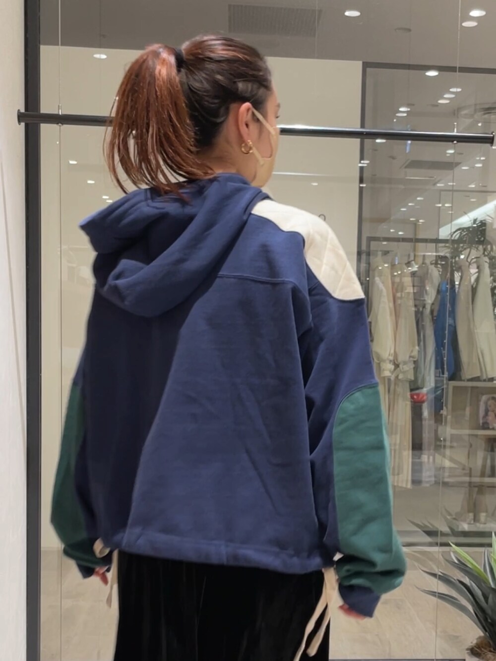 ブラック系のワンピース、ブラック系のブーツ、ブルー系のパーカーを着用したレディースの冬コーディネートの2枚目の写真