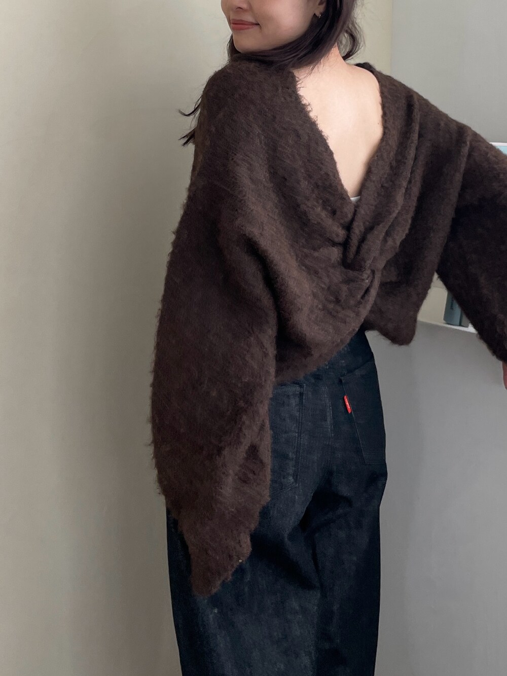 ブラウン系のニット/セーターを着用したレディースの秋コーディネートの2枚目の写真