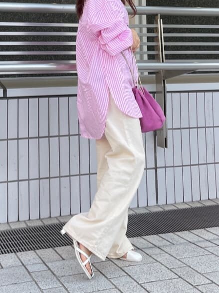 ピンク系のハンドバッグ、ピンク系のシャツ/ブラウス、ホワイト系のサンダルを着用したレディースの春コーディネートの3枚目の写真