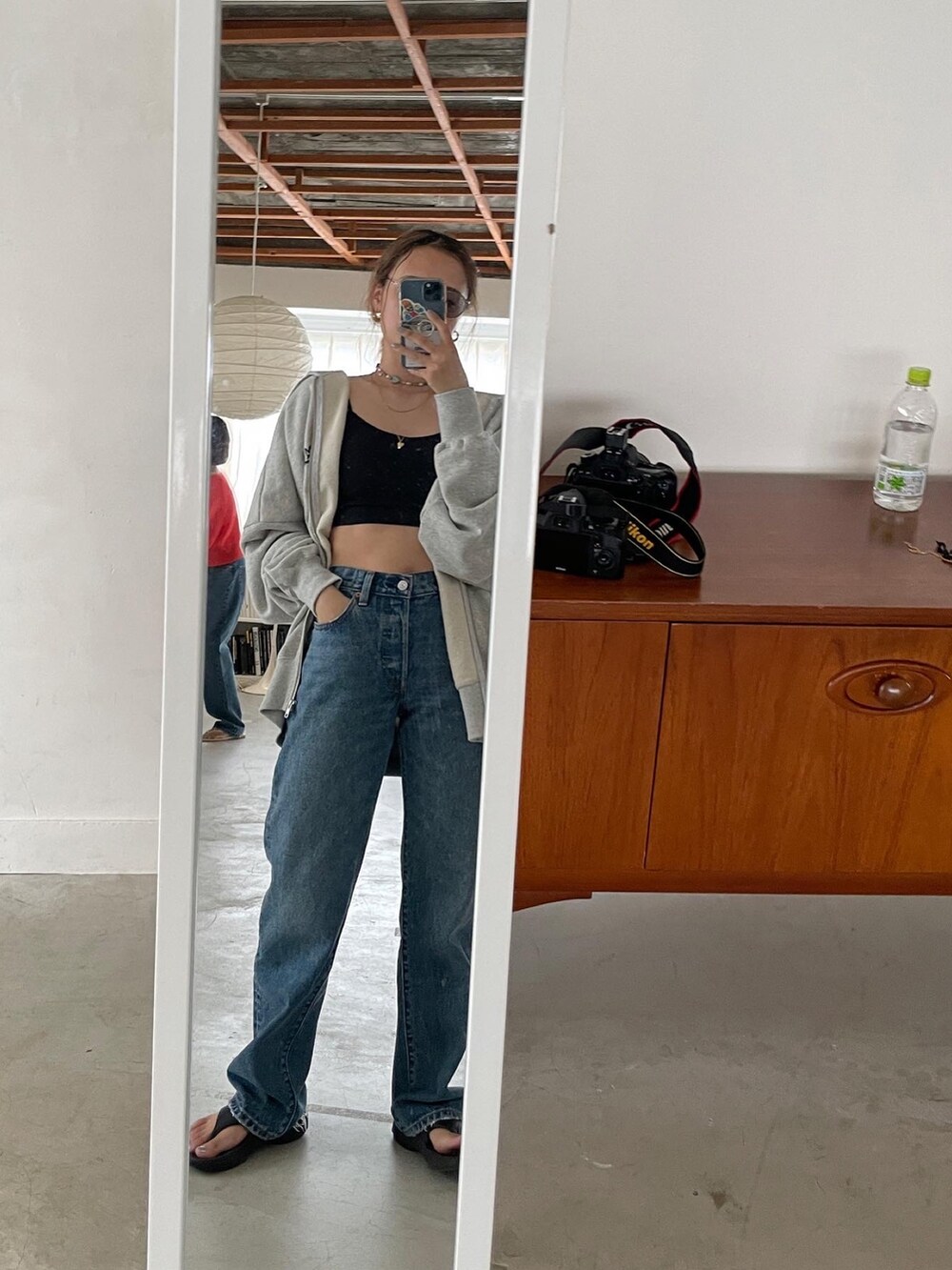 ブルー系のデニムパンツ、ブラック系のキャミソール、グレー系のパーカーを着用したレディースの夏コーディネートの2枚目の写真