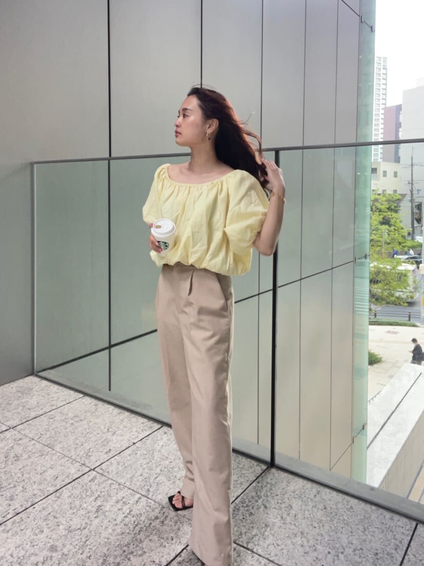 ベージュ系のその他パンツ、イエロー系のシャツ/ブラウス、ゴールド系のブレスレットを着用したレディースの春コーディネートの3枚目の写真