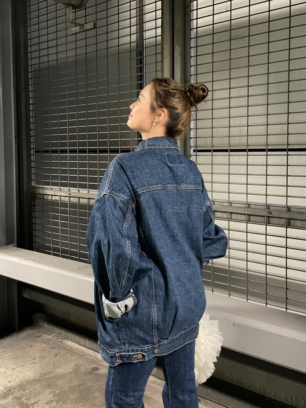 ホワイト系のショルダーバッグ、ブルー系のデニムジャケット、ブルー系のデニムパンツを着用したレディースの夏コーディネートの5枚目の写真