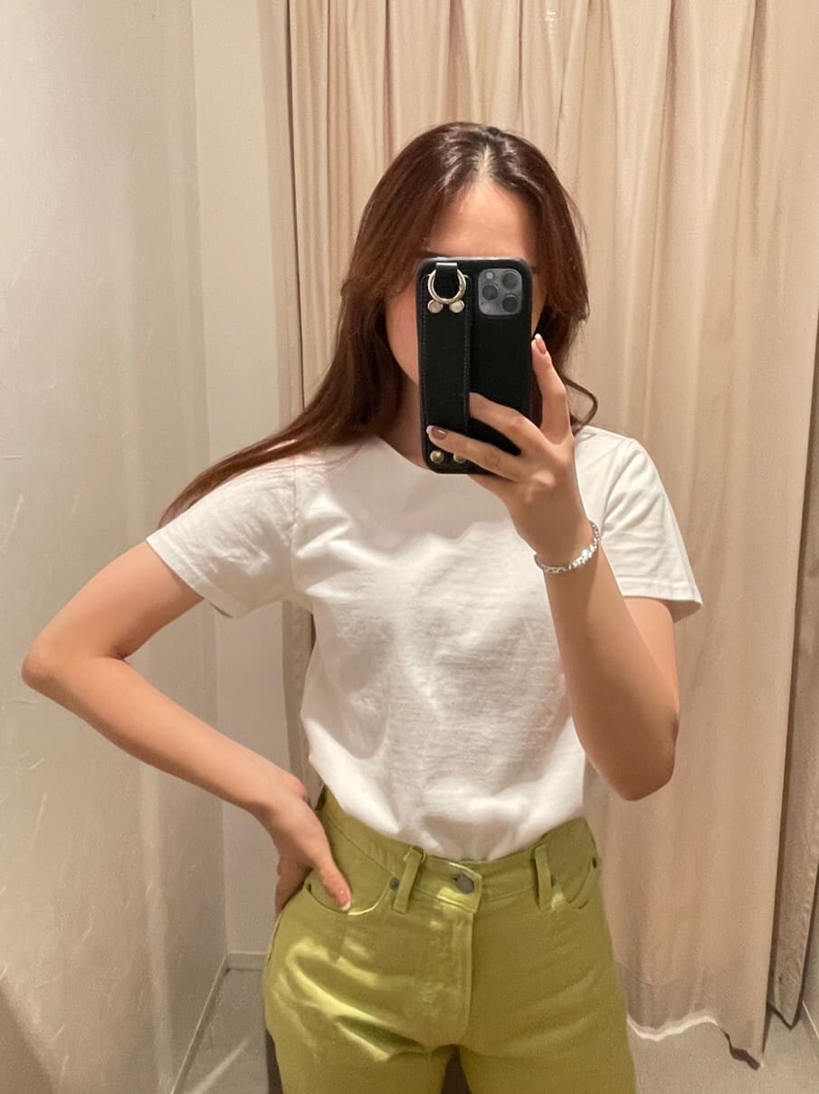 グリーン系のデニムパンツ、ホワイト系のTシャツ/カットソー、シルバー系のブレスレットを着用したレディースの春コーディネートの4枚目の写真