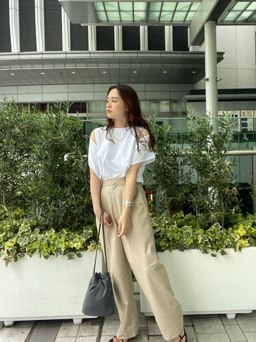 ベージュ系のその他パンツ、ホワイト系のTシャツ/カットソー、グレー系のハンドバッグを着用したレディースの春コーディネートの2枚目の写真
