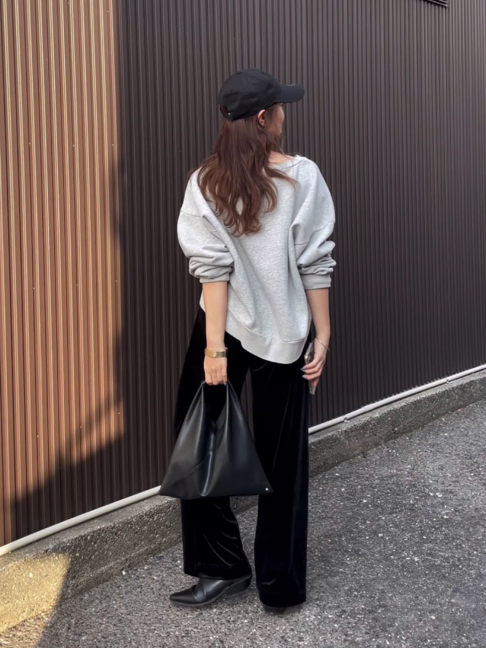 グレー系のスウェット、ブラック系のブーツを着用したレディースの冬コーディネートの2枚目の写真
