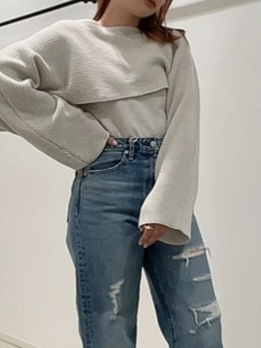 ホワイト系のニット/セーター、ブルー系のデニムパンツ、ホワイト系のサンダルを着用したレディースの春コーディネートの2枚目の写真