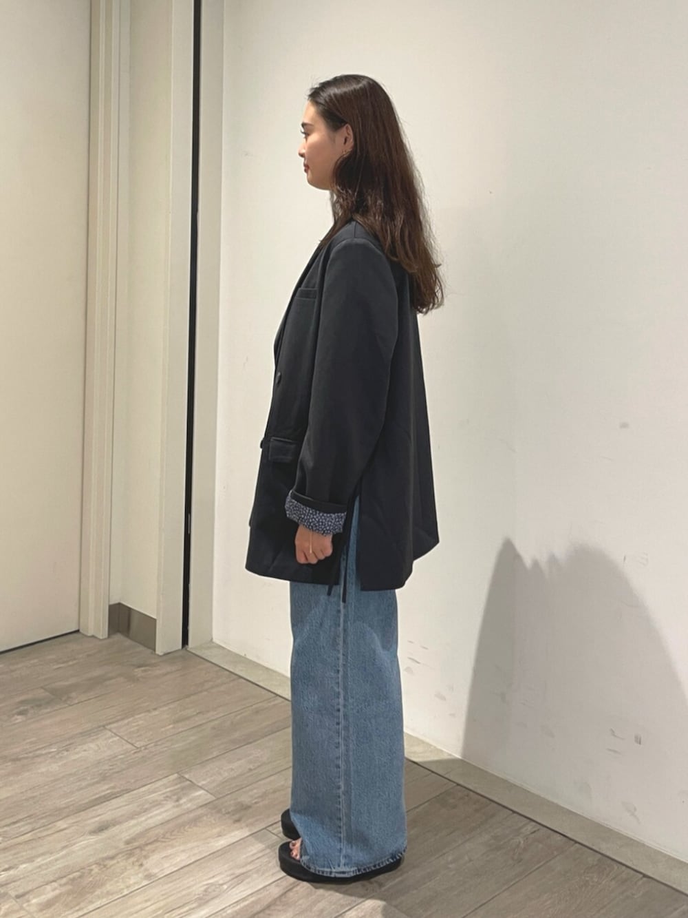 ブルー系のデニムパンツ、グレー系のテーラードジャケットを着用したレディースの夏コーディネートの2枚目の写真
