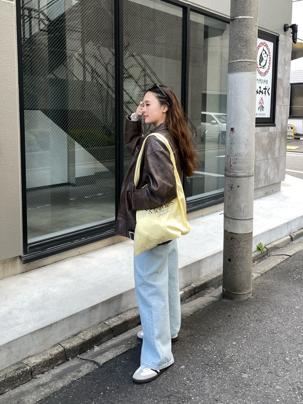 ブラウン系のブルゾン、ブルー系のデニムパンツ、イエロー系のエコバッグ/サブバッグを着用したレディースの冬コーディネートの5枚目の写真