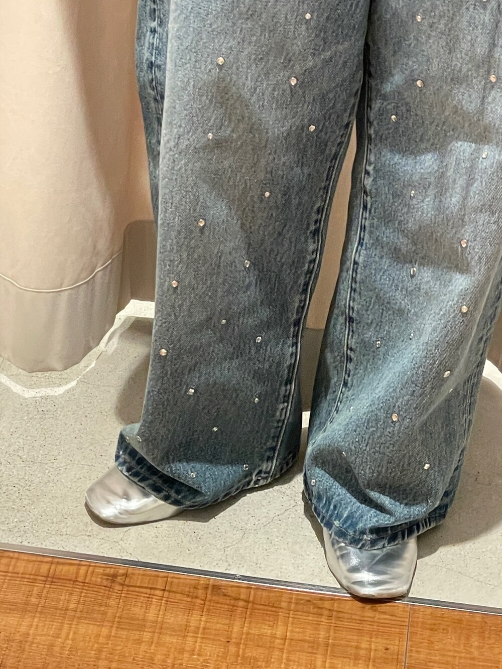 シルバー系のパンプス、ブルー系のデニムパンツを着用したレディースの秋コーディネートの2枚目の写真