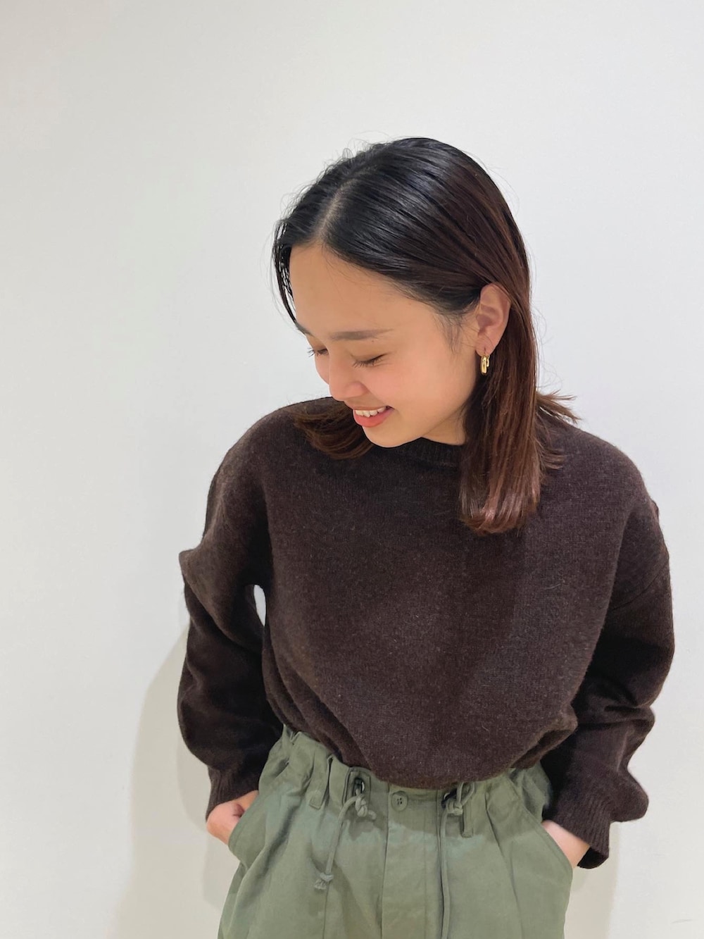 ブラウン系のムートンコート、パープル系のニット/セーター、ベージュ系のその他パンツを着用したレディースの冬コーディネートの6枚目の写真