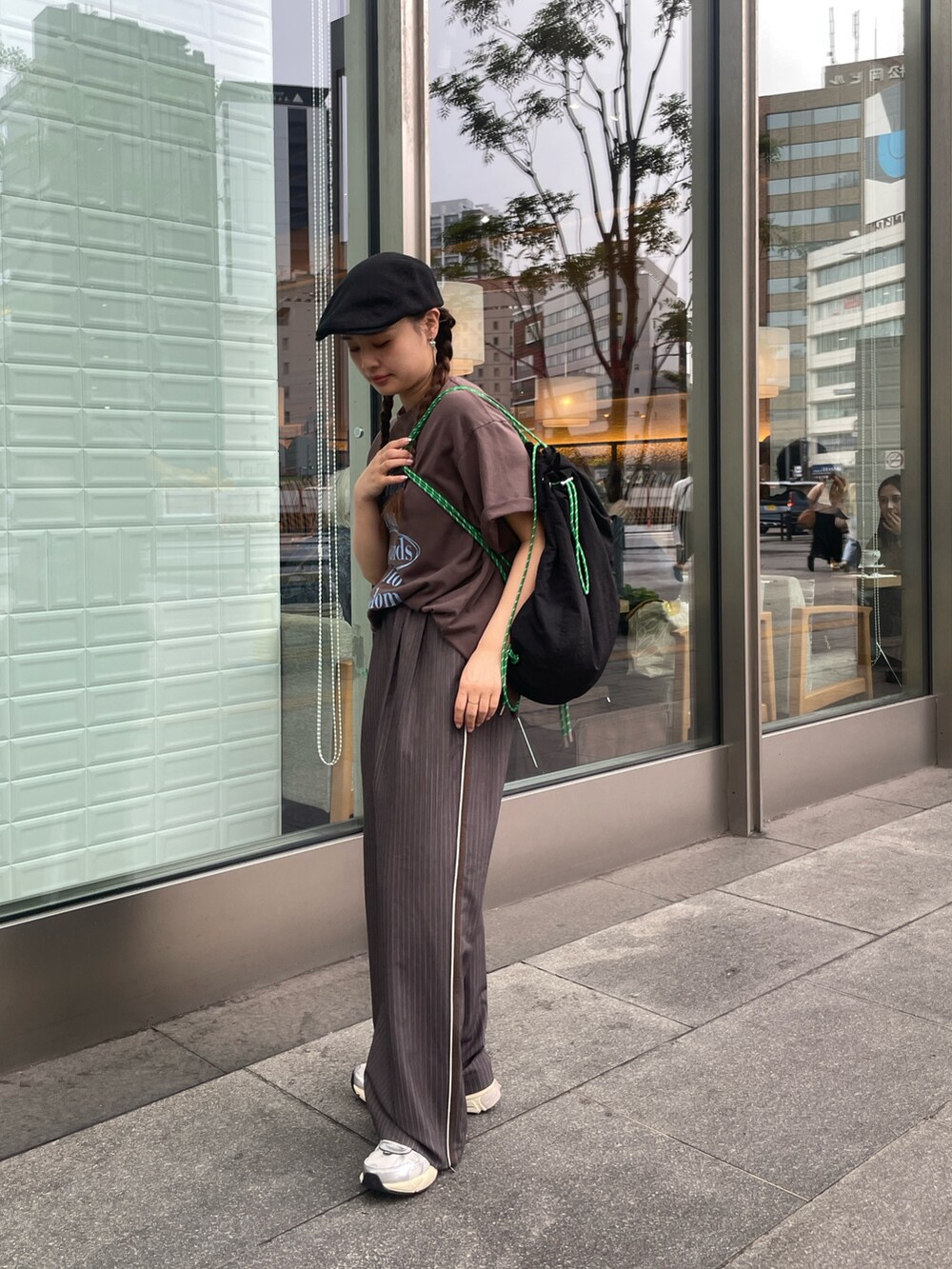 グレー系のその他パンツ、ブラウン系のTシャツ/カットソー、ブラック系のバックパック/リュックを着用したレディースの春コーディネートの3枚目の写真