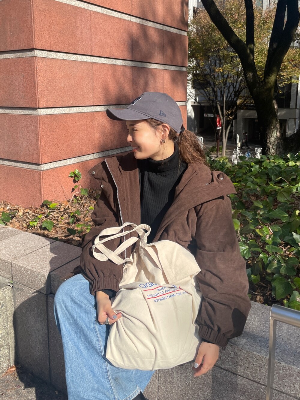 ブルー系のデニムパンツ、ブラウン系のブルゾン、ブラック系のニット/セーターを着用したレディースの冬コーディネートの7枚目の写真