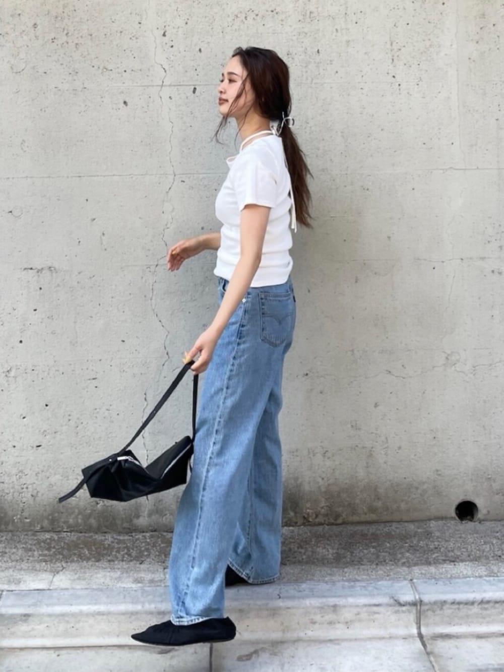ブラック系のパンプス、ブルー系のデニムパンツ、ホワイト系のTシャツ/カットソーを着用したレディースの夏コーディネートの3枚目の写真