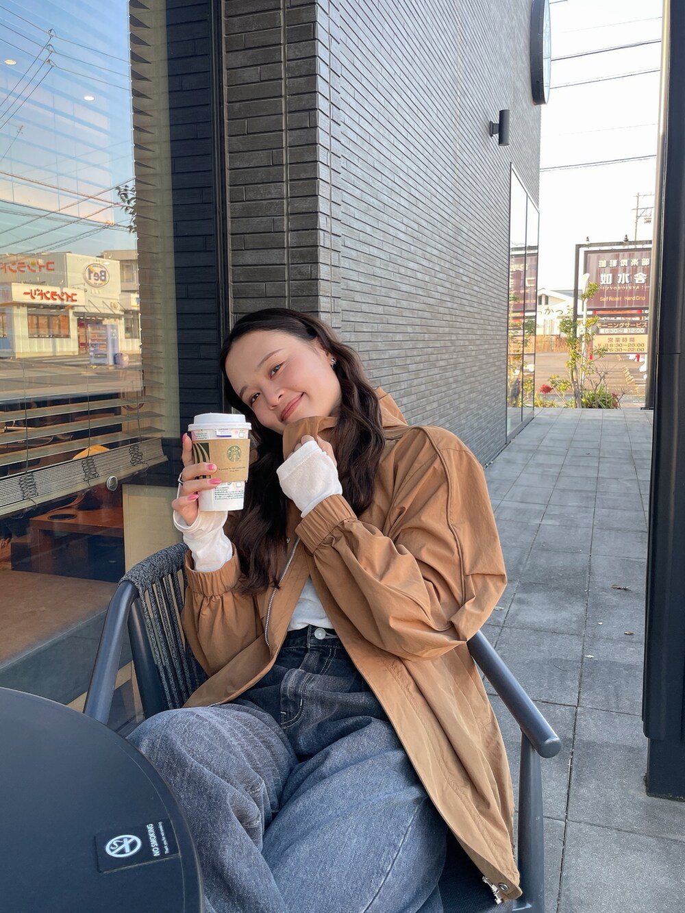 ブラック系のデニムパンツ、ベージュ系のブルゾン、ホワイト系のTシャツ/カットソーを着用したレディースの冬コーディネートの3枚目の写真