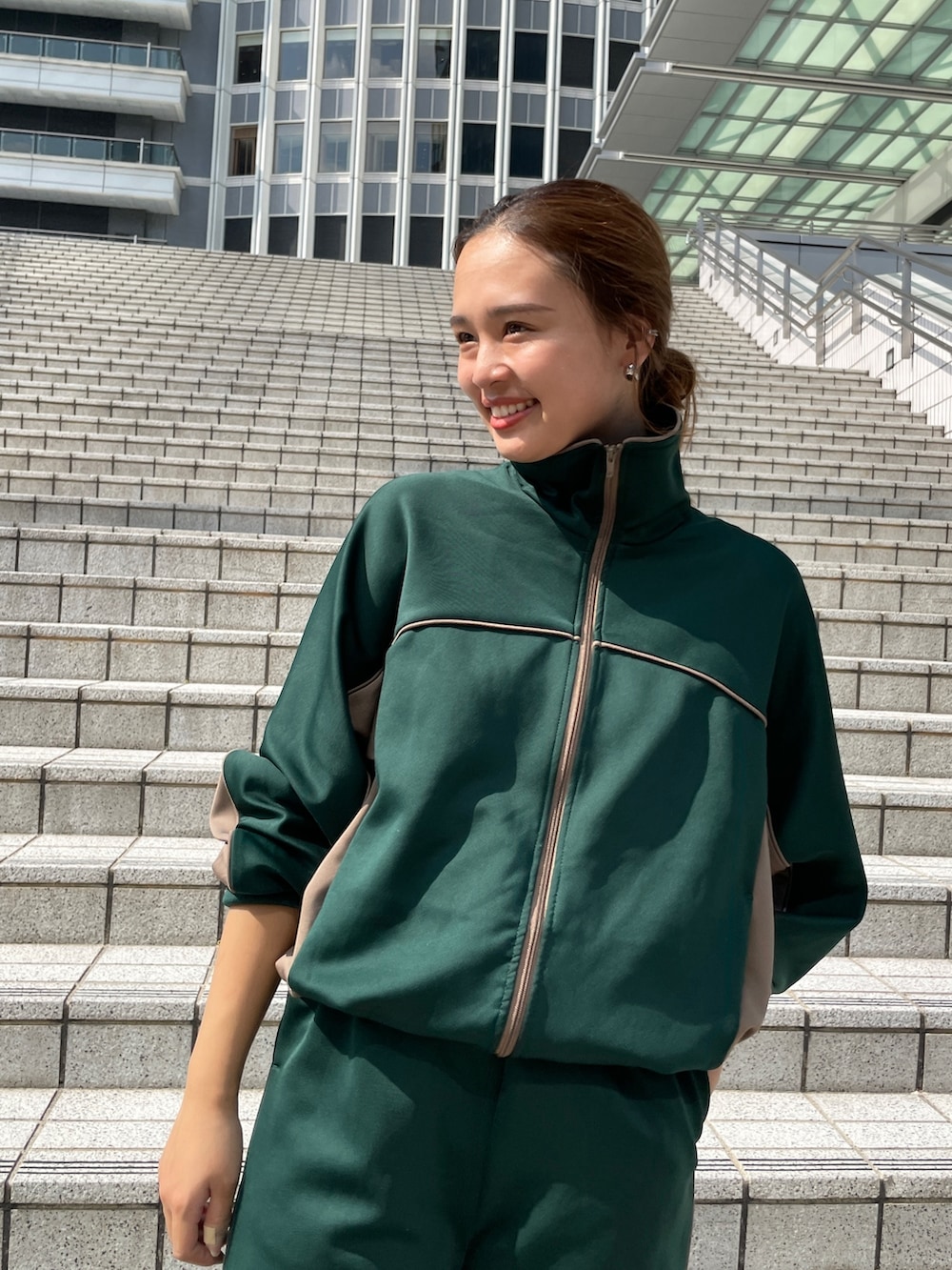 グリーン系のブルゾン、グリーン系のその他パンツ、ホワイト系のダウンベストを着用したレディースの秋コーディネートの10枚目の写真