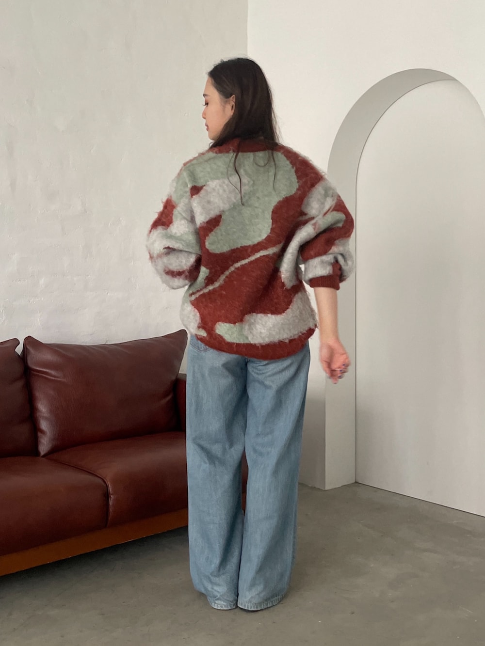 オレンジ系のニット/セーター、ブルー系のデニムパンツ、ブラック系のローファーを着用したレディースの秋コーディネートの3枚目の写真