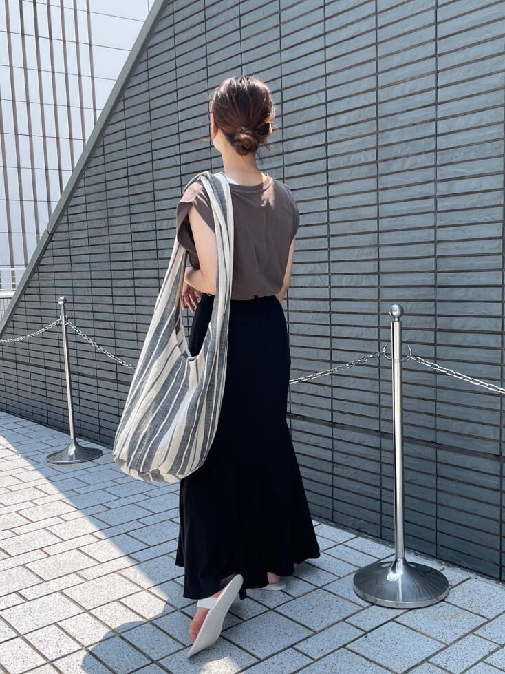ホワイト系のサンダル、ブラウン系のタンクトップ、ブラック系のスカートを着用したレディースの夏コーディネートの4枚目の写真