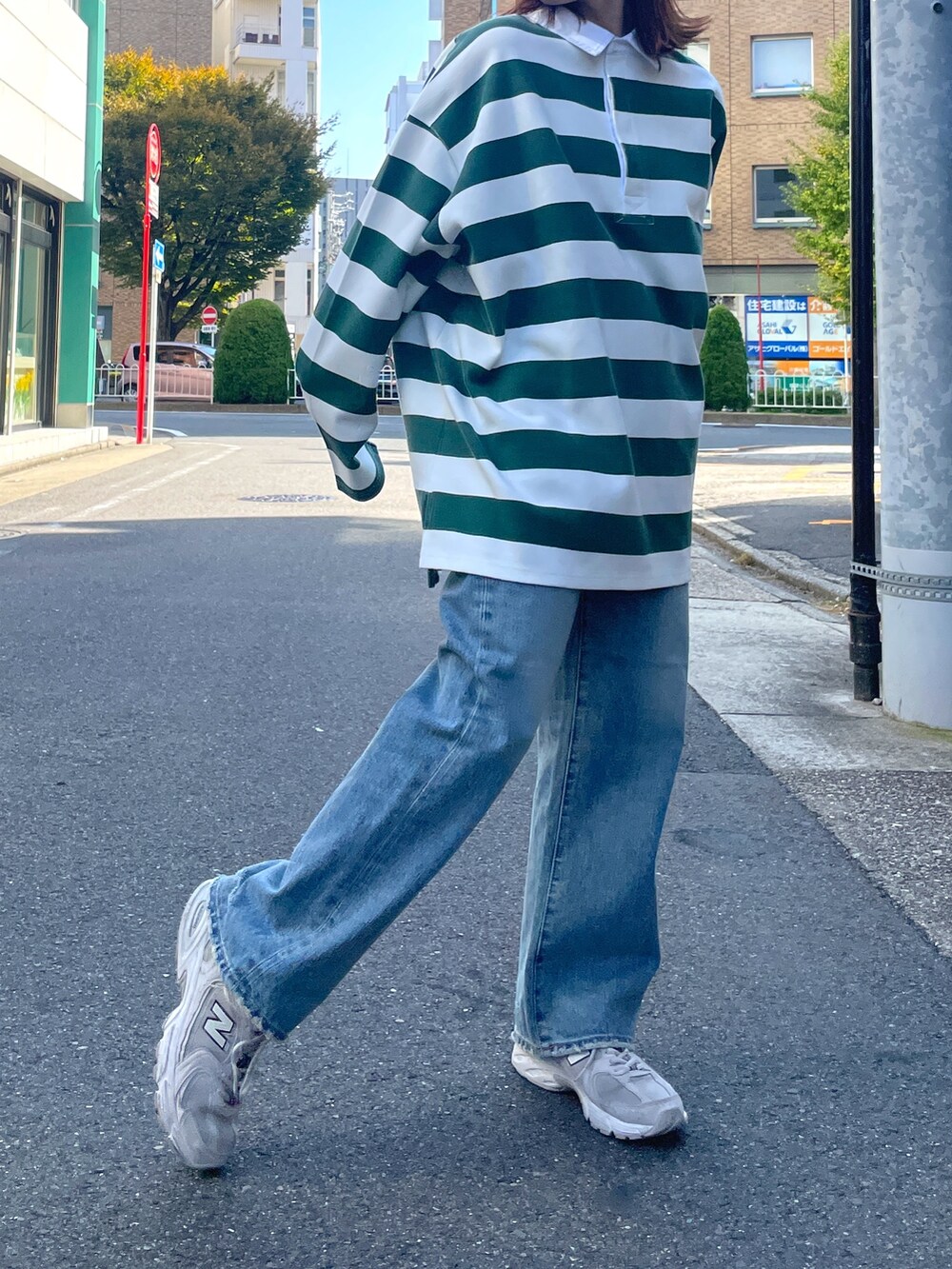 グリーン系のTシャツ/カットソー、ブルー系のデニムパンツを着用したレディースの秋コーディネートの5枚目の写真