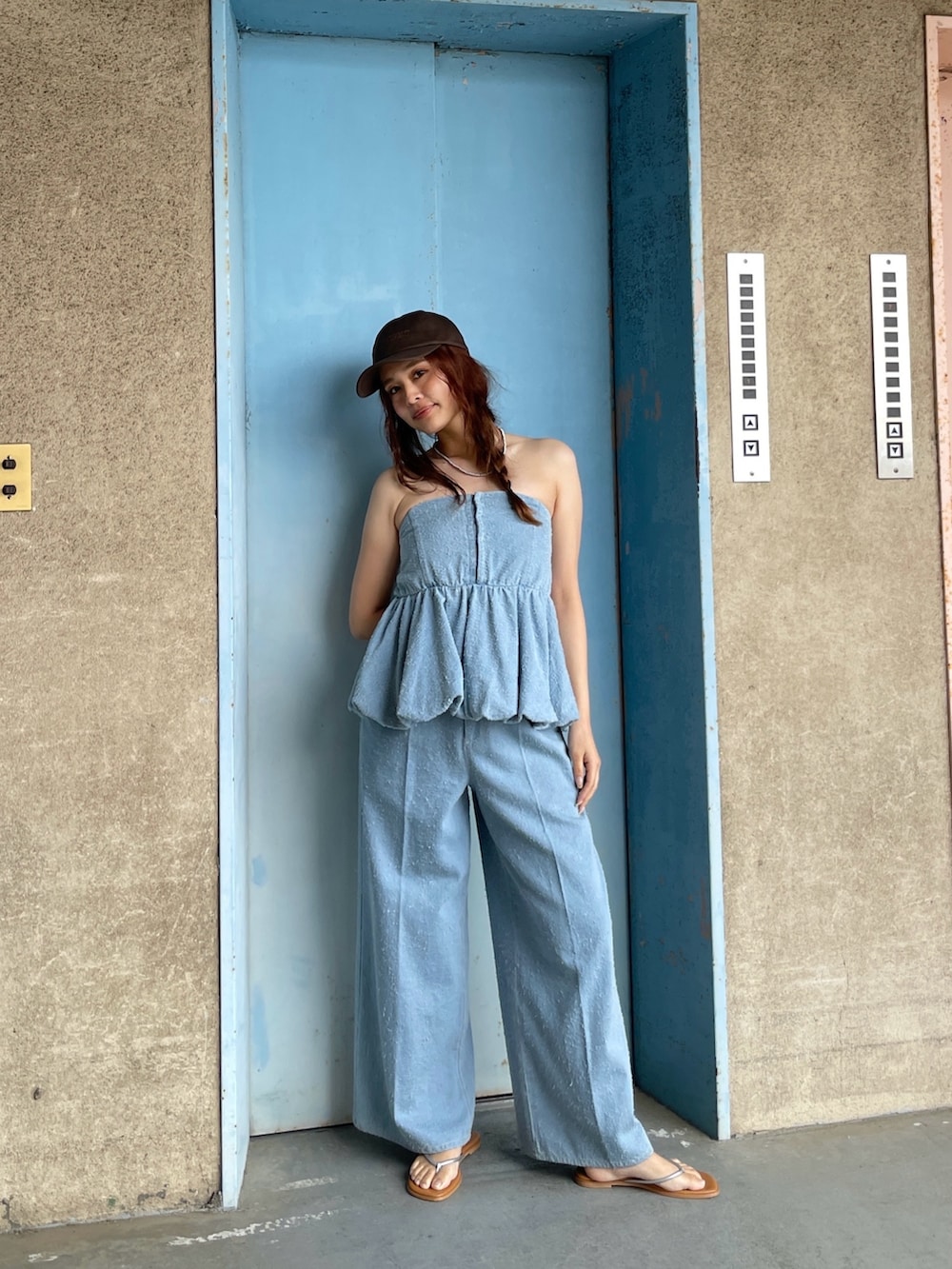 ブルー系のチューブトップ、ブルー系のデニムパンツを着用したレディースの春コーディネートの5枚目の写真