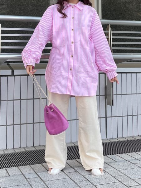 ピンク系のハンドバッグ、ピンク系のシャツ/ブラウス、ホワイト系のサンダルを着用したレディースの春コーディネートの5枚目の写真