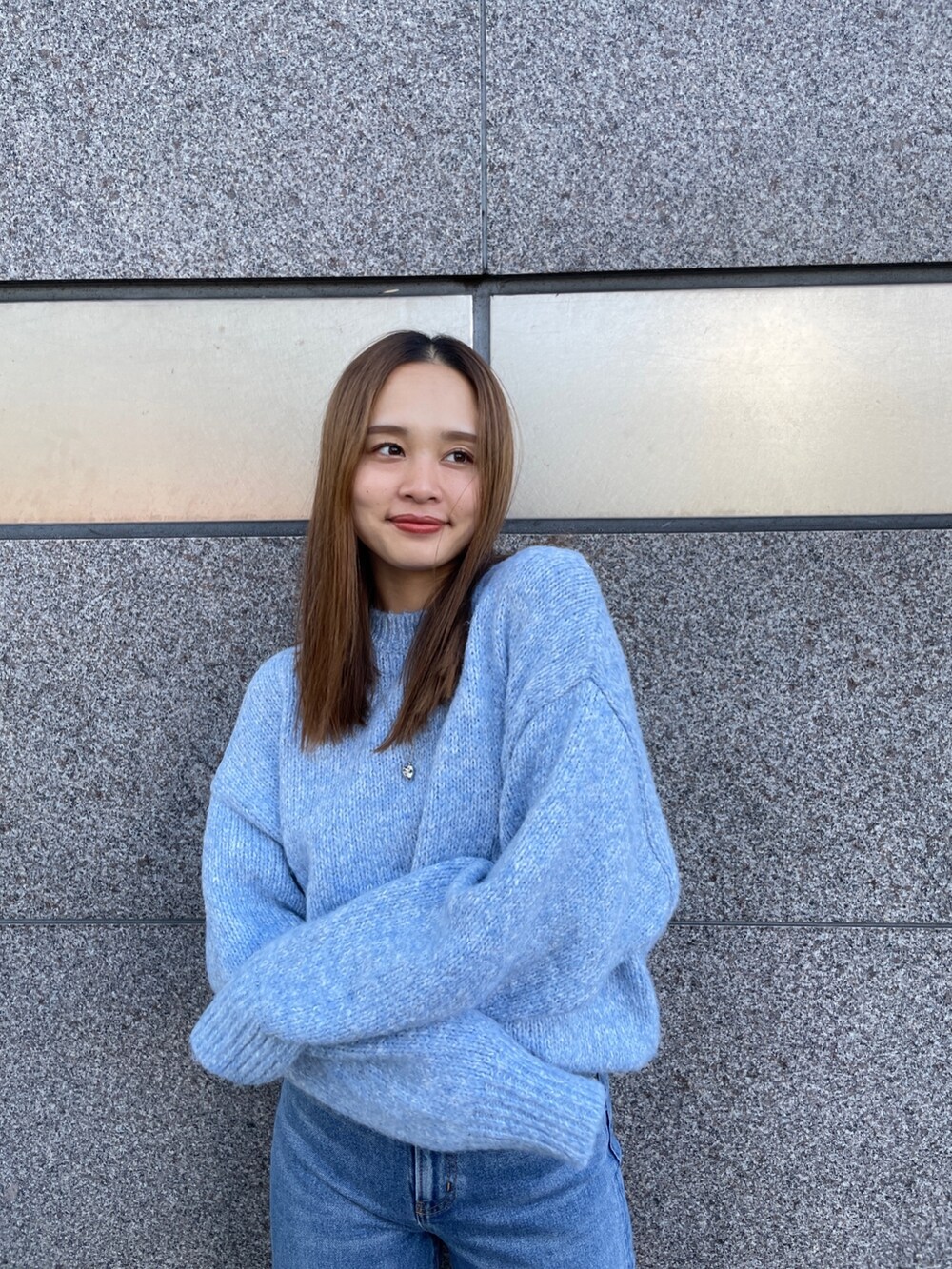 ブラック系のブルゾン、ブルー系のニット/セーター、ブルー系のデニムパンツを着用したレディースの秋コーディネートの4枚目の写真