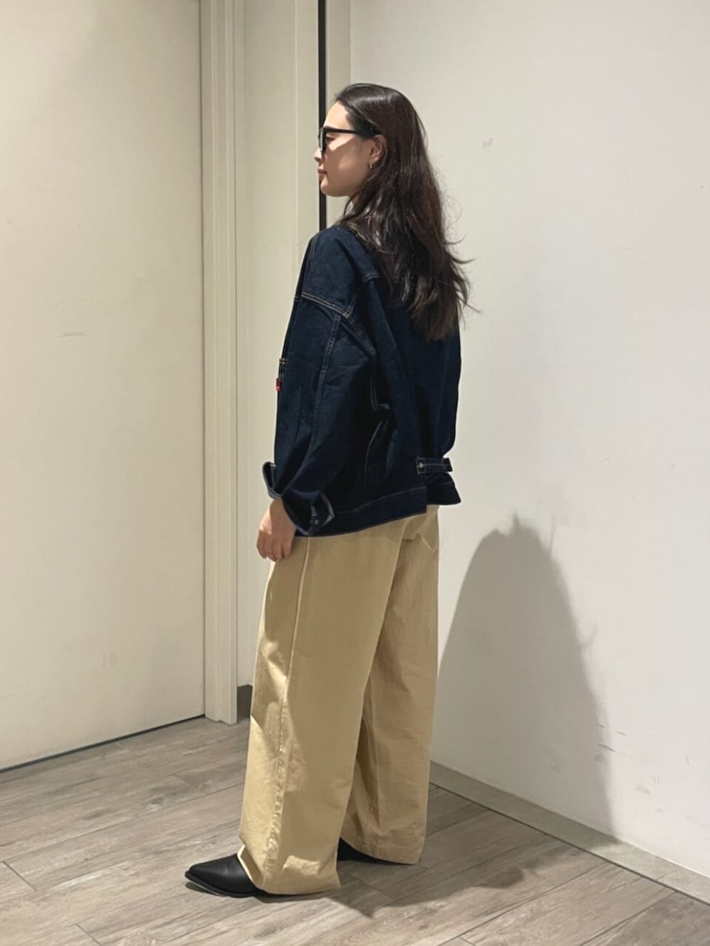ベージュ系のその他パンツ、ブラック系のブーツ、ブルー系のデニムジャケットを着用したレディースの夏コーディネートの2枚目の写真
