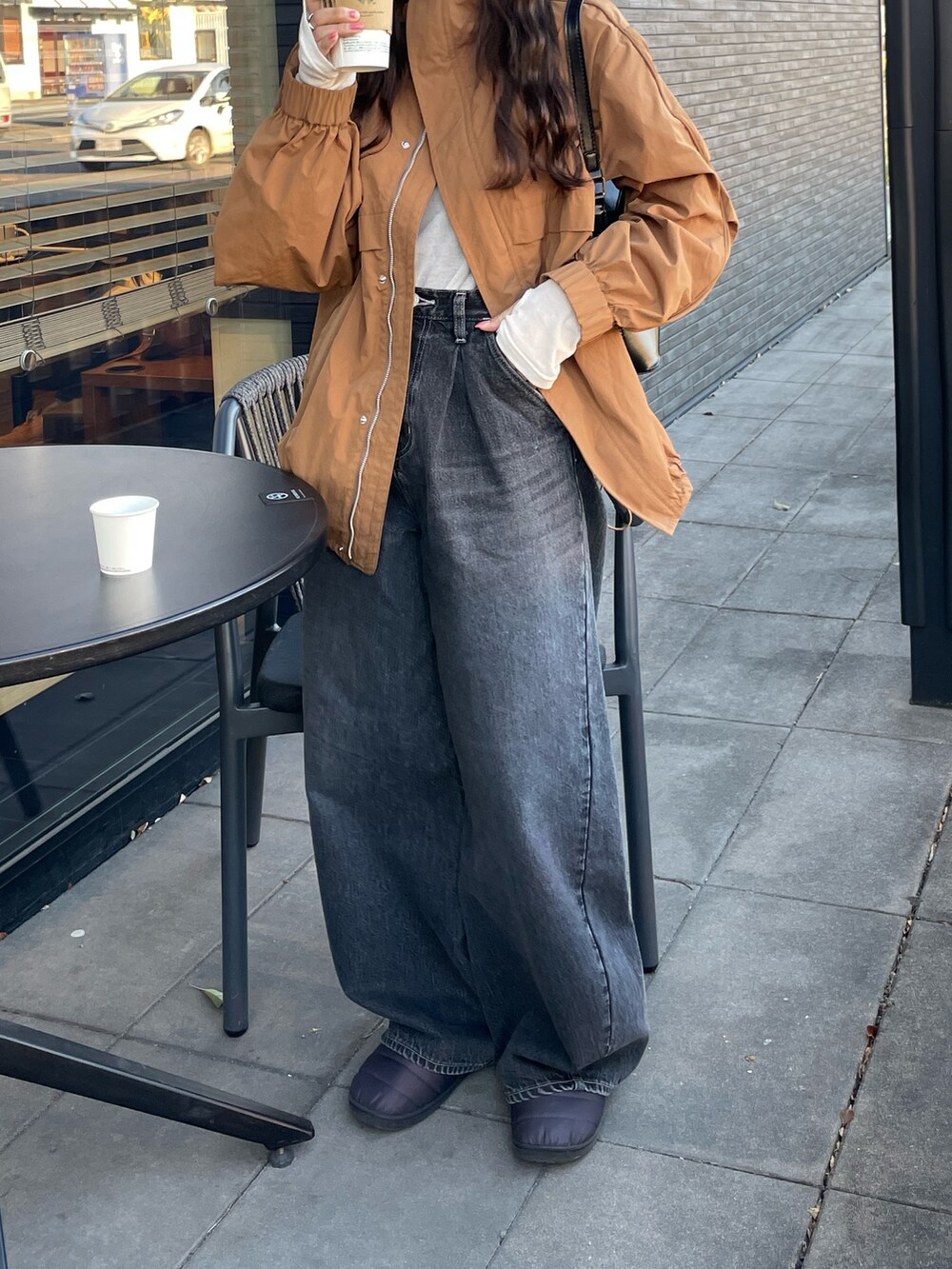 ブラック系のデニムパンツ、ベージュ系のブルゾン、ホワイト系のTシャツ/カットソーを着用したレディースの冬コーディネートの6枚目の写真