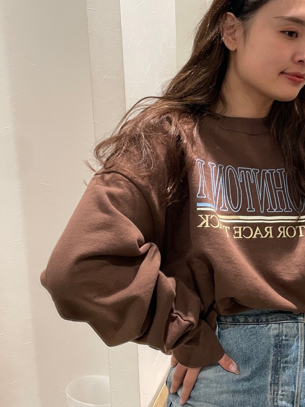 ホワイト系のスウェット、ブルー系のデニムパンツを着用したレディースの冬コーディネートの4枚目の写真