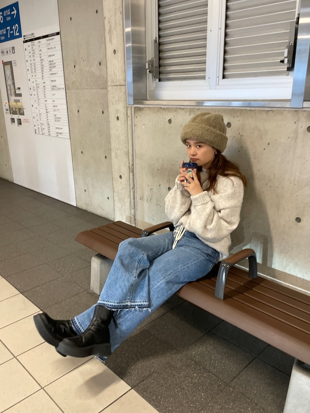 ホワイト系のニット/セーター、ブルー系のデニムパンツを着用したレディースの冬コーディネートの2枚目の写真