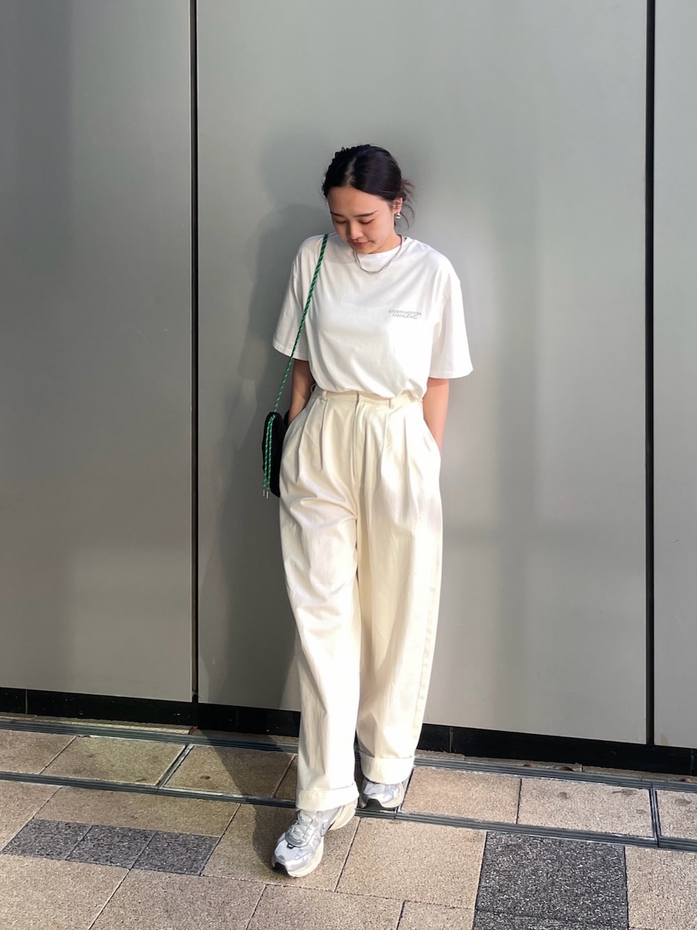 ホワイト系のTシャツ/カットソー、ホワイト系のチノパンツ、ブラック系のバックパック/リュックを着用したレディースの夏コーディネートの4枚目の写真