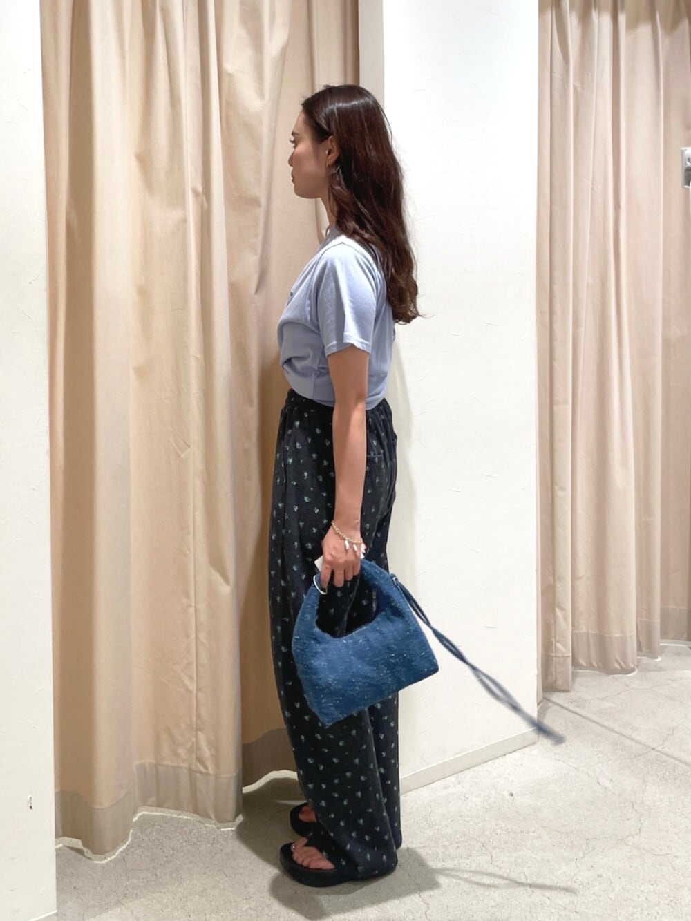 グレー系のその他パンツ、ブルー系のTシャツ/カットソー、ブルー系のハンドバッグを着用したレディースの夏コーディネートの2枚目の写真