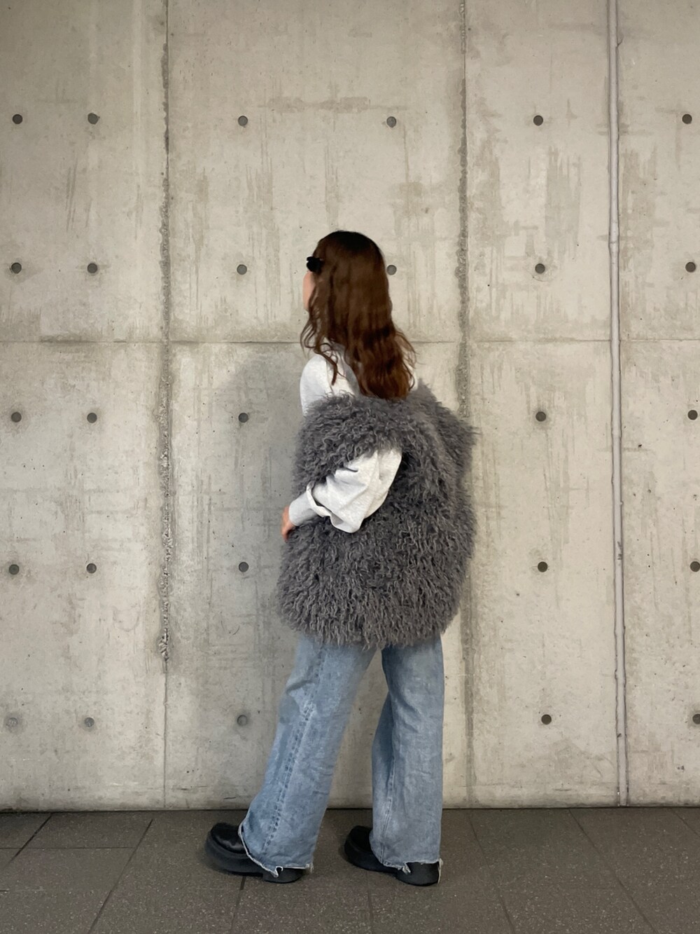 ブルー系のデニムパンツ、グレー系のスウェット、グレー系のベストを着用したレディースの冬コーディネートの6枚目の写真