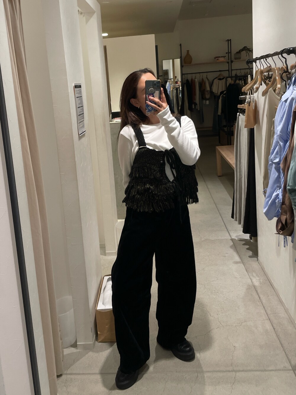 ホワイト系のTシャツ/カットソー、ブラック系のニット/セーター、ブラック系のデニムパンツを着用したレディースの秋コーディネートの2枚目の写真