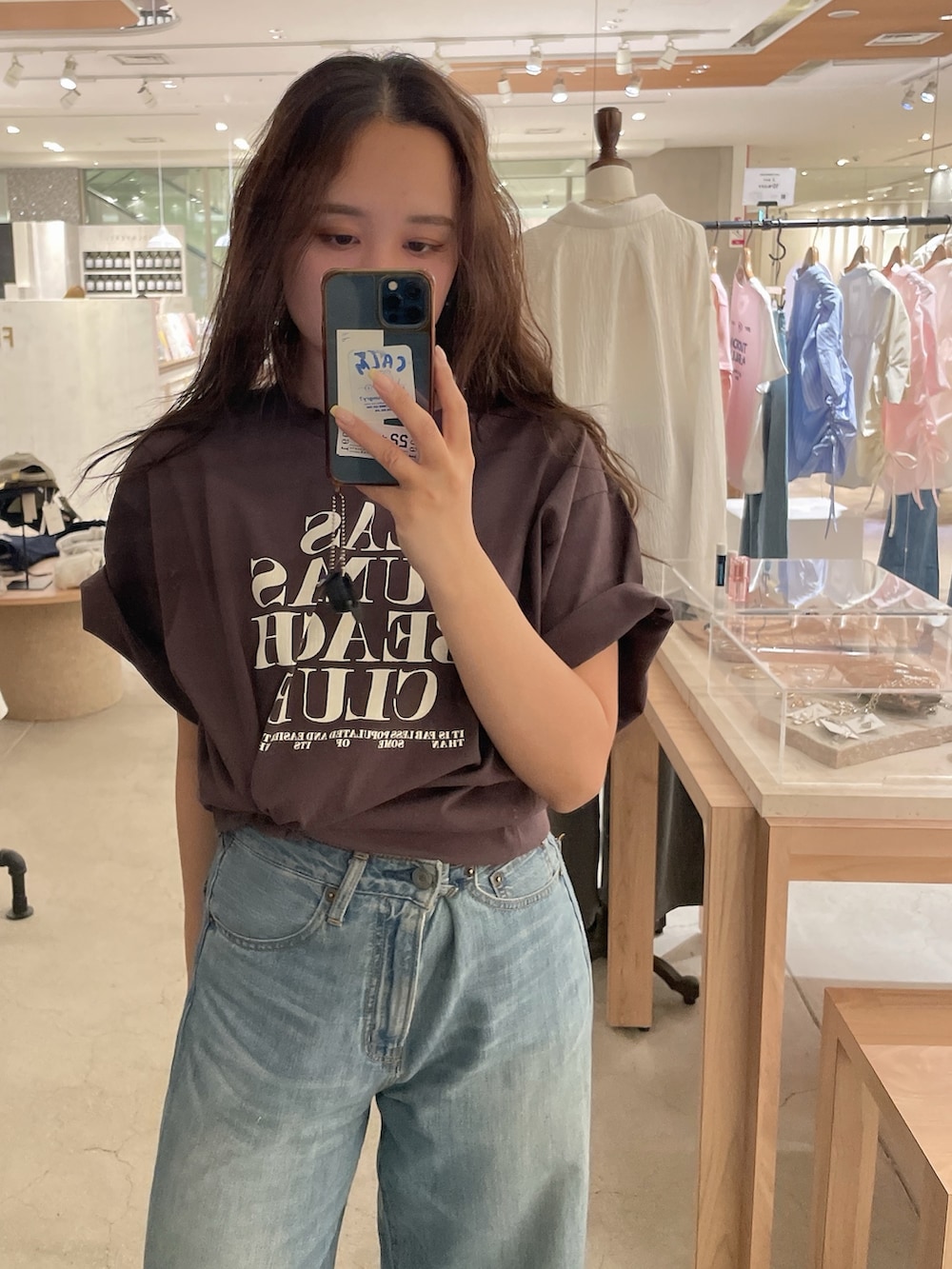 ブルー系のデニムパンツ、ブラウン系のTシャツ/カットソーを着用したレディースの春コーディネートの2枚目の写真