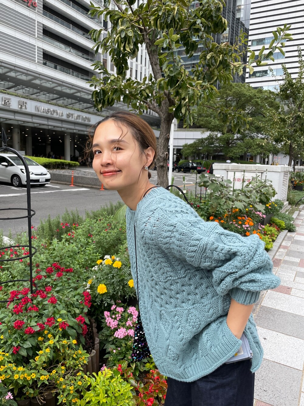 ブルー系のニット/セーター、ブルー系のデニムパンツ、その他のショルダーバッグを着用したレディースの秋コーディネートの4枚目の写真