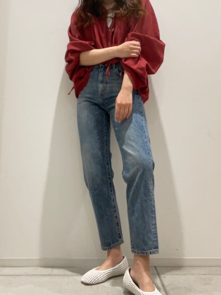 ホワイト系のパンプス、ホワイト系のタンクトップ、ブルー系のデニムパンツを着用したレディースの春コーディネートの3枚目の写真