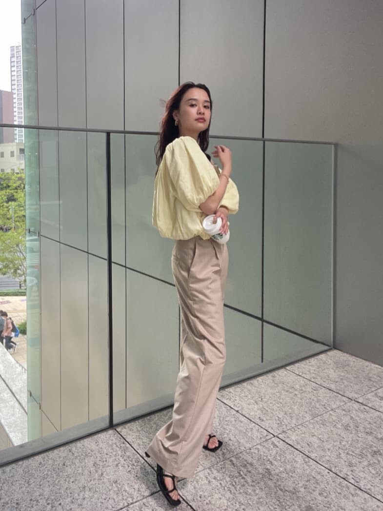 ベージュ系のその他パンツ、イエロー系のシャツ/ブラウス、ゴールド系のブレスレットを着用したレディースの春コーディネートの4枚目の写真