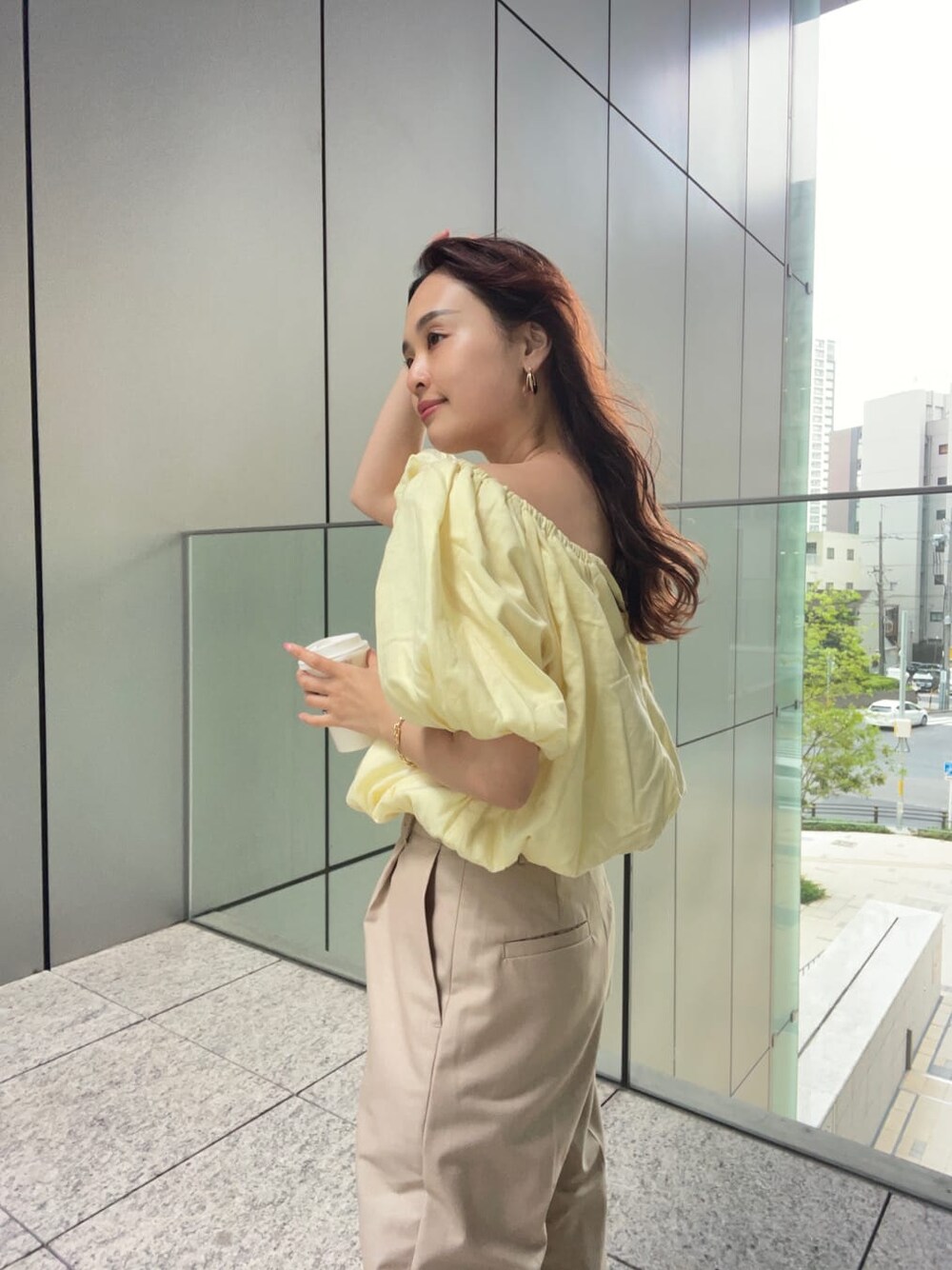 ベージュ系のその他パンツ、イエロー系のシャツ/ブラウス、ゴールド系のブレスレットを着用したレディースの春コーディネートの6枚目の写真