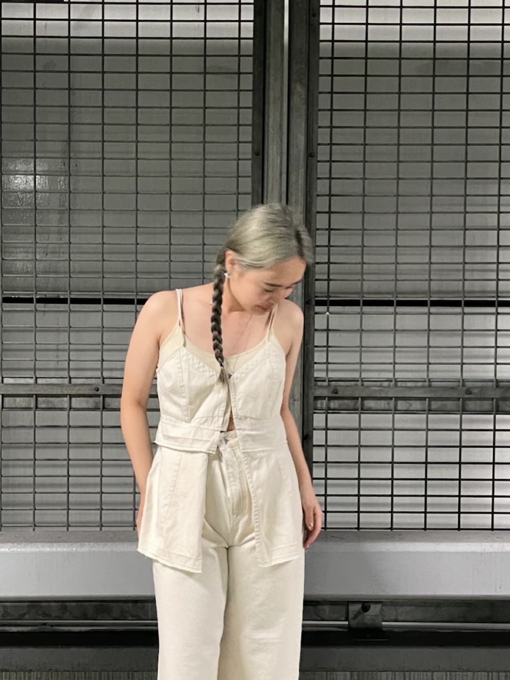 ホワイト系のデニムパンツ、ホワイト系のキャミソール、シルバー系のサンダルを着用したレディースの春コーディネートの3枚目の写真