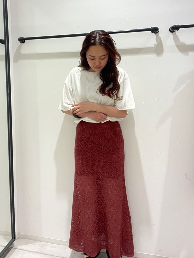 ホワイト系のTシャツ/カットソー、オレンジ系のスカート、ブラウン系のブレスレットを着用したレディースの春コーディネートの2枚目の写真