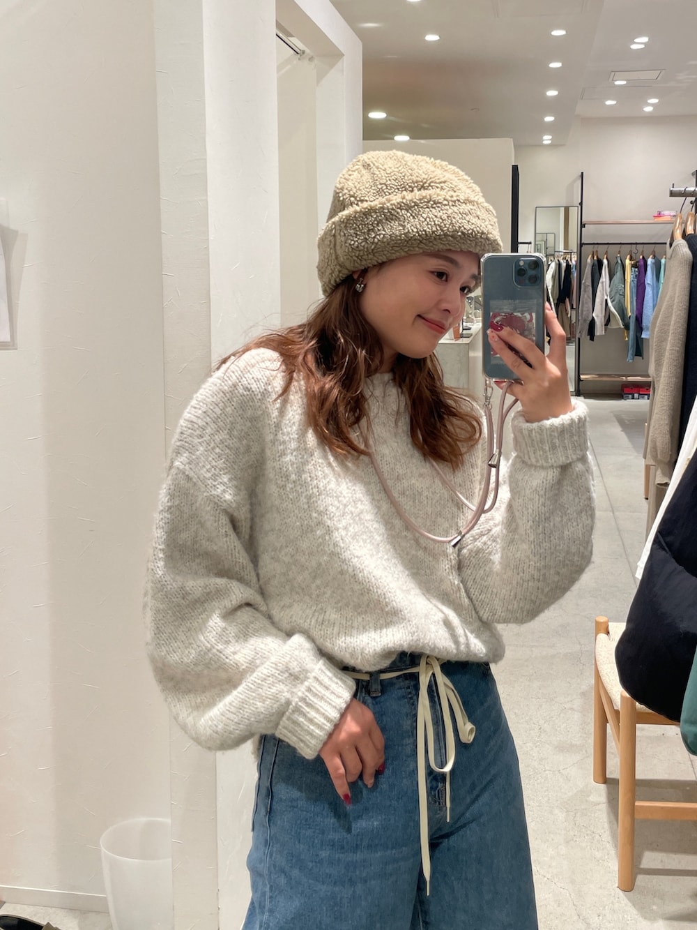 ホワイト系のニット/セーター、ブルー系のデニムパンツを着用したレディースの冬コーディネートの6枚目の写真