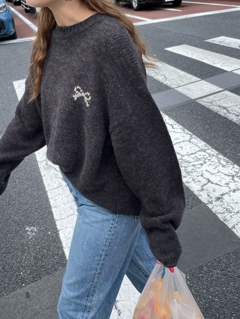 グレー系のニット/セーター、ブルー系のデニムパンツ、ブラック系のニットキャップ/ビーニーを着用したレディースの秋コーディネートの3枚目の写真