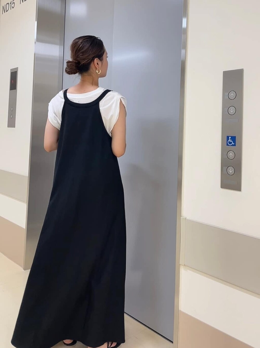 ブラック系のサンダル、ホワイト系のタンクトップ、ブラック系のワンピースを着用したレディースの夏コーディネートの3枚目の写真