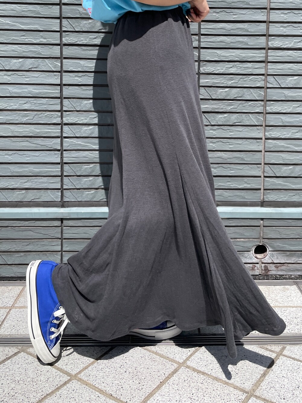 ブルー系のTシャツ/カットソー、グレー系のスカート、ブルー系のスニーカーを着用したレディースの春コーディネートの4枚目の写真